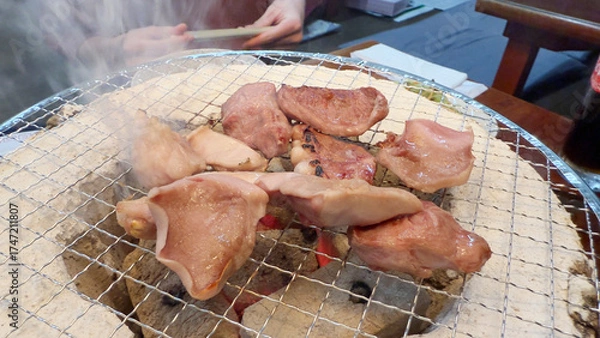 Fototapeta 焼肉屋で七輪炭焼き　豚たんと豚バラに炎