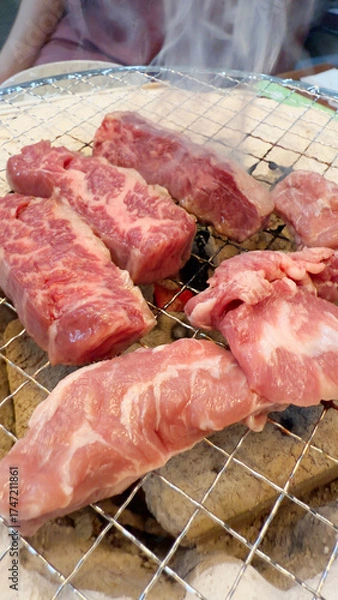 Fototapeta 焼肉屋で七輪炭焼き　豚たんと豚バラに炎