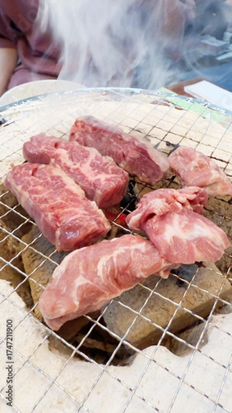 Fototapeta 焼肉屋で七輪炭焼き　豚たんと豚バラに炎
