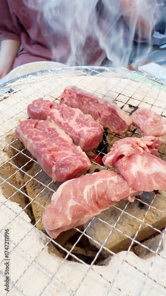 Fototapeta 焼肉屋で七輪炭焼き　豚たんと豚バラに炎