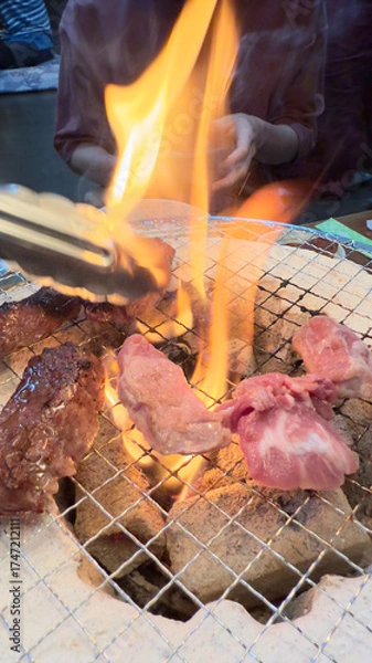 Fototapeta 焼肉屋で七輪炭焼き　豚たんと豚バラに炎