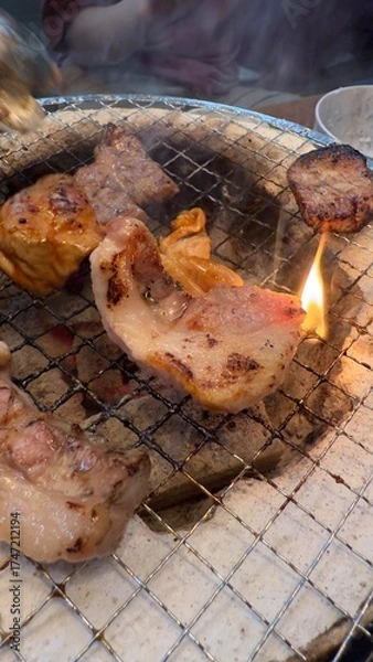 Fototapeta 焼肉屋で七輪炭焼き　豚たんと豚バラに炎