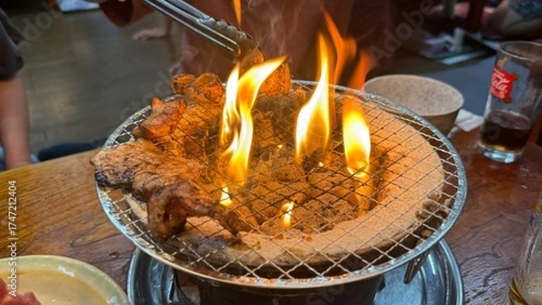 Fototapeta 焼肉屋で七輪炭焼き　豚たんと豚バラに炎