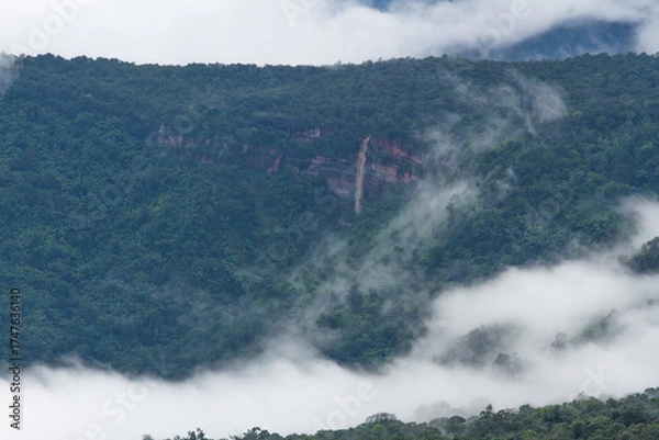 Fototapeta waterfall in mountain forest with cloud around 