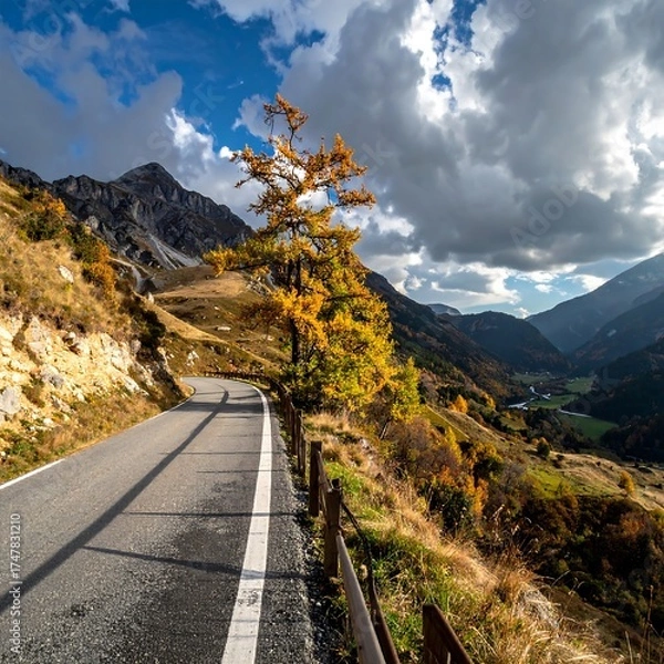 Obraz Winding road through mountains, autumn tree, dramatic sky