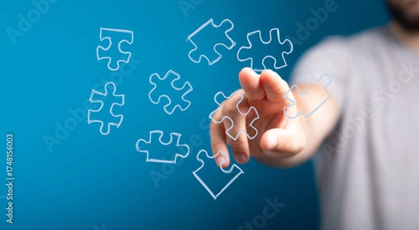 Fototapeta Hand reaching for puzzle pieces.  Solution, strategy, teamwork, success, connection, problem-solving, innovation, ideas.