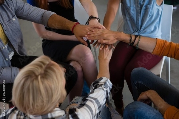 Fototapeta High angle view of friends stacking hands