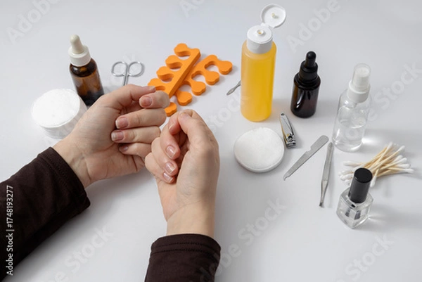 Fototapeta Woman has problems with her nails and she is going to rake care of it at the beauty salon. White manicure desk set and accessories on it