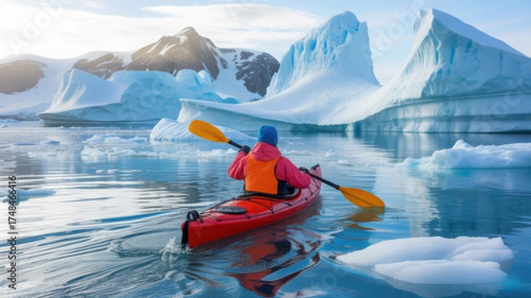 Fototapeta Kayaker paddles through a stunning glacial landscape with towering icebergs under a bright sky