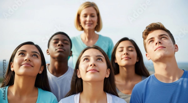 Obraz Inspiring portrait of a multiethnic group of students with their teacher, looking up together with faith and aspiration for a bright future