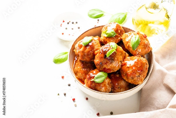 Fototapeta Glazed Meatballs in tomato sauce on white table.