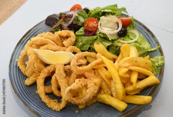 Fototapeta Fried squid rings with french fries and salad
