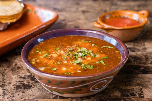 Fototapeta Red birria de res stew with cilantro and onion, served with salsa and tortillas