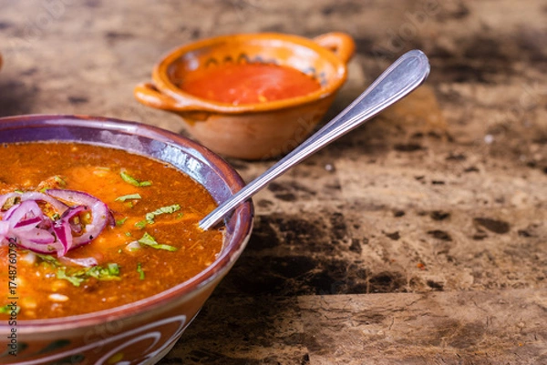 Fototapeta Birria stew topping with red onion and cilantro ready to eat