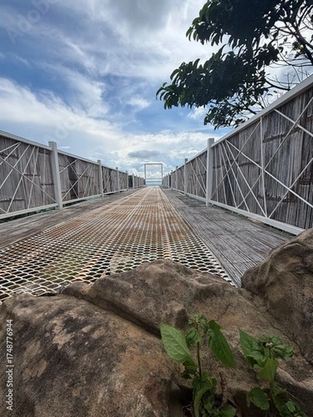 Fototapeta The walkway to window frame with cloudy sky in background
