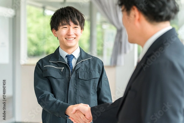 Fototapeta 握手をする作業着姿の男性ビジネスマン,作業員
