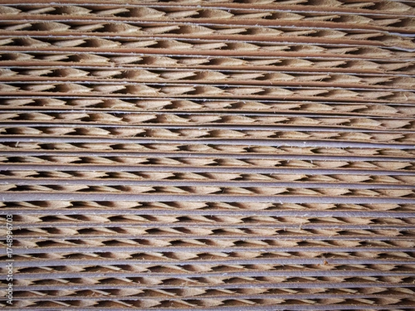 Fototapeta Macro view of stacked corrugated cardboard sheets showing cut edges and fluted texture. Ideal for abstract backgrounds, packaging design, or material studies.