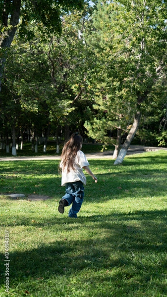 Obraz A 9-year-old girl runs in the park in summer