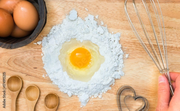 Obraz Top view composition flour with egg and ingredients for homemade bakery on wooden background