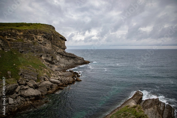 Obraz Scenic coastal cliff landscape overlooking the rough sea under cloudy skies perfect for nature and travel photography