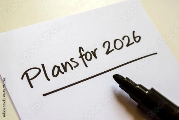 Fototapeta New year intention setting. Plans for 2026. Handwritten marker inscription on a white sheet of paper standing on the table, close-up