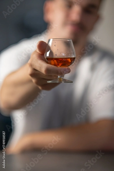 Obraz petit verre de cognac dnas la main d'un homme, tendre un verre d'alcool