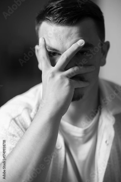 Fototapeta regard au travers de la main, portrait d'un jeune homme en noir et blanc