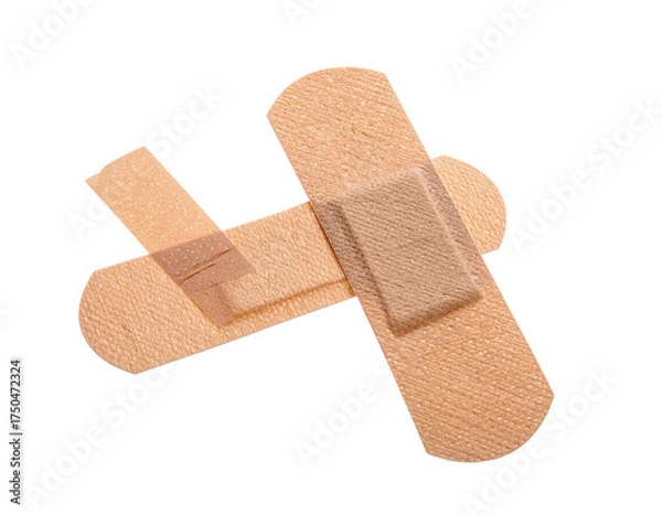 Obraz Two flesh-toned adhesive bandages arranged in a cross-like fashion, isolated on black