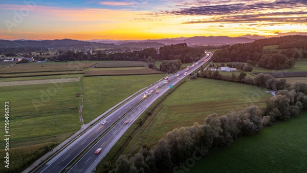 Fototapeta An aerial view of the highway cutting through the picturesque Slovenian countryside near Krtina village by Lukovica, bathed in the warm glow of sunset.