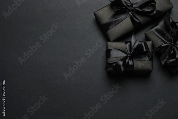 Fototapeta Black Friday. Top view of black gift boxes tied with ribbons,  on a dark backdrop, providing space for your message or promotion