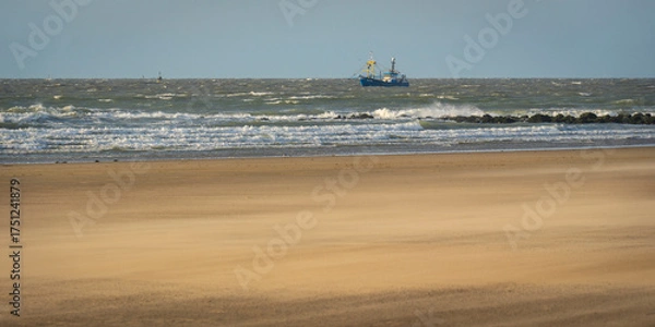 Fototapeta single ship is sailing on the North Sea, ship, sails and waves shine in the evening light, North Sea beach before sunset with waves of the ocean