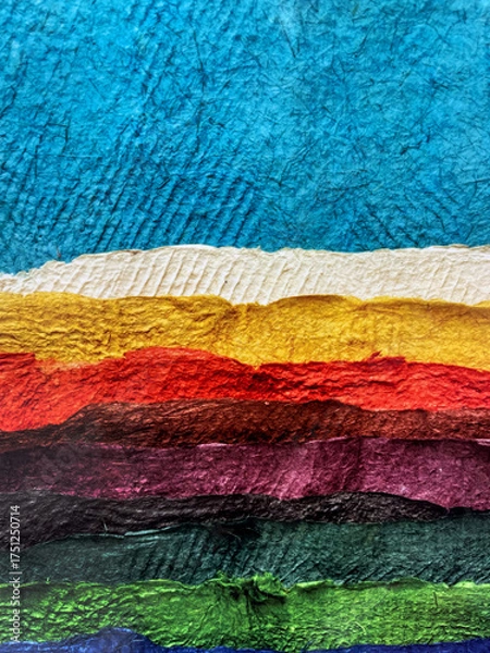 Obraz Colorful layered paper texture in vivid shades of blue, yellow, red, purple, green, and brown. Abstract handmade background with torn edges and rough surface, creative craft art design.