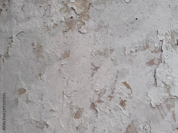 Obraz Old wall with cracked and peeling white paint. Weathered plaster texture showing natural decay and rough surface, perfect for grunge backgrounds, vintage or architectural design projects.