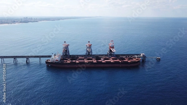 Obraz Large bulk carrier ship docking - Unloading coal ship by cranes on the power station dock