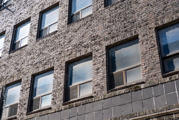 Fototapeta An old brick building with a classic window and the reflection of the sky