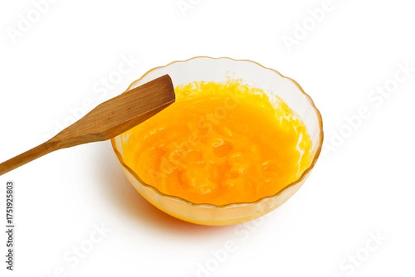 Fototapeta Closeup glass bowl with fresh homemade pumpkin puree and wooden spatula isolated on clean white background