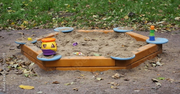 Fototapeta A children's sandbox at the edge of the playground near the lawn