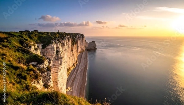 Fototapeta A picturesque coastal scene captured at sunset. Cliffside structures overlook a calm sea reflecting the golden light, painting a serene panorama