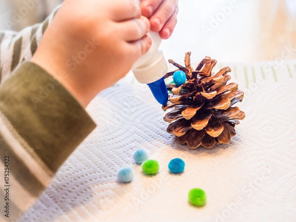 Obraz Child's Hands Gluing Pinecone Craft