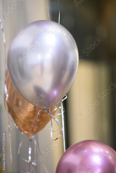 Fototapeta Festive metallic balloons float gracefully in the air creating a celebratory atmosphere for a special event or party occasion with shimmering ribbons.