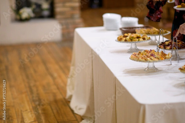 Fototapeta Elegant catered buffet table laden with a delightful assortment of sweet pastries and savory appetizers ready for guests to enjoy at a sophisticated event