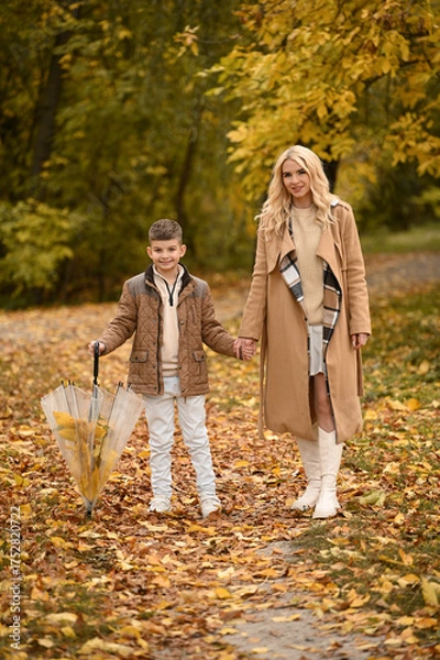 Fototapeta mother and son playing in the autumn park