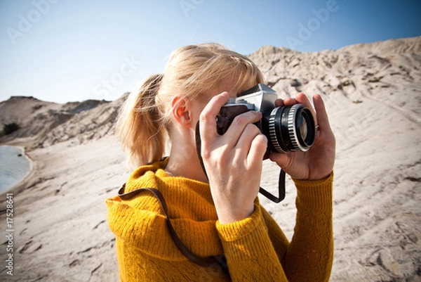 Fototapeta woman with a old camera taking photos in the desert