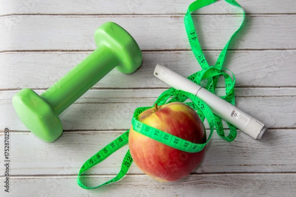 Obraz Healthy lifestyle concept with dumbbell, measuring tape, apple and Wegovy injection pen. Weight loss support and fitness background.