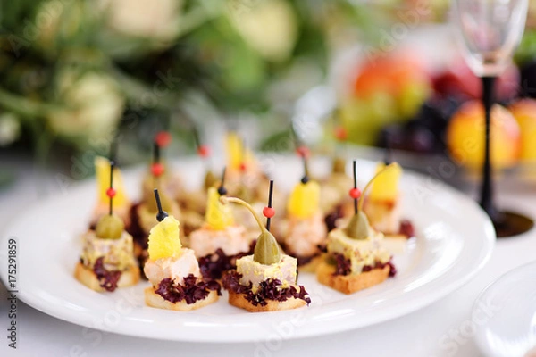 Obraz Delicious canape snacks with pineapple and capers topping served on a party or wedding reception