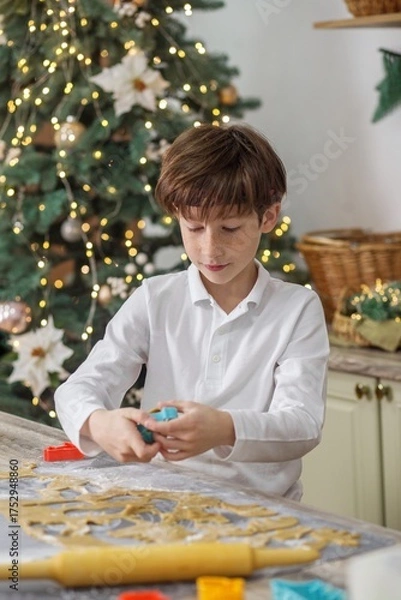 Obraz Boy cutting Christmas cookies from dough