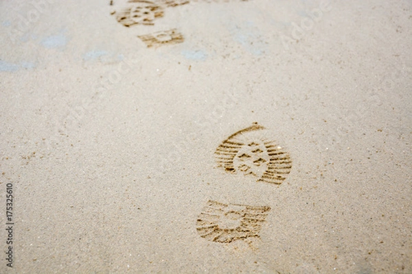 Fototapeta Footprints of shoes in the sand from the front