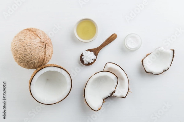 Fototapeta Domowe produkty kokosowe na tle biały drewniany stół. Olej, peeling, mleko i balsam z widoku z góry. Dobre dla przestrzeni i tła.