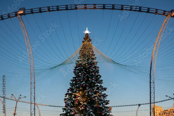 Fototapeta Christmas tree and New Year decorations on the town square on a frosty winter day.
