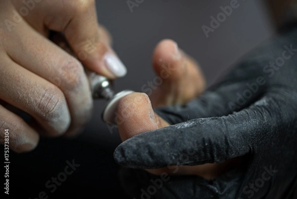 Obraz Electric file tool used during professional pedicure procedure to smooth toe skin in beauty salon